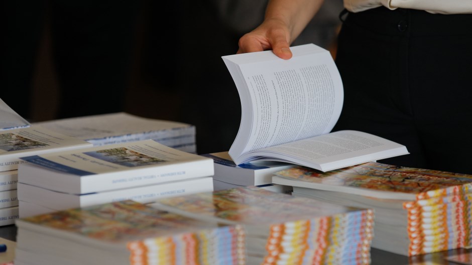 Auf einem Tisch sind verschiene Broschüren aufeinander gestapelt.